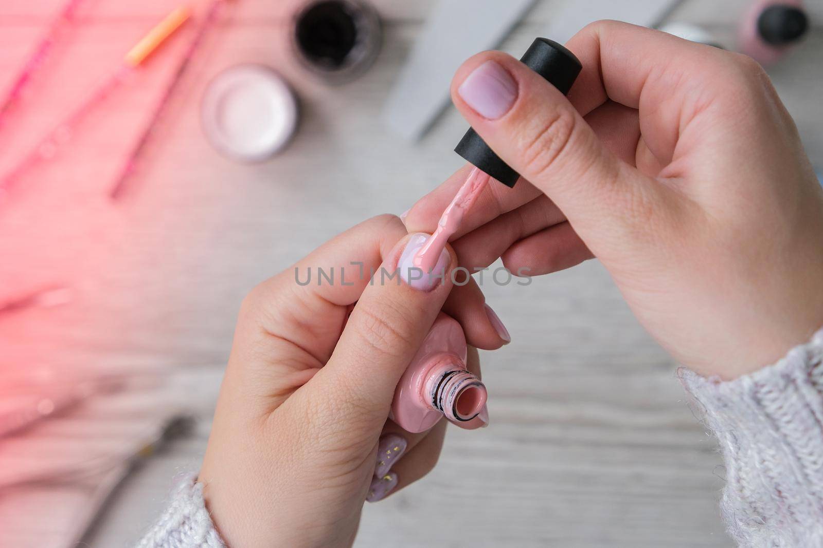 Modern female nude design manicure. Nail care, Self care. Do manicure by yourself while staying at home. Female hands and manicure tools. Spa salon. Professional Hardware Manicure. Procedure for the preparation of nails. Cuticle Pusher Remover. Nail file scissors