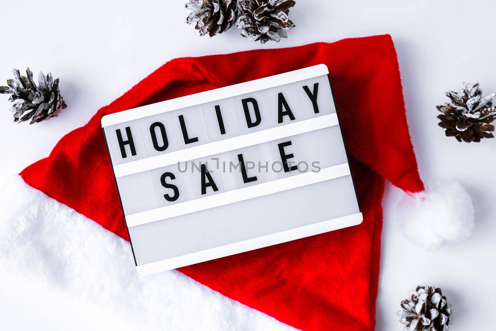 Lightbox with text HOLIDAY SALE around christmas new year decoration. Santas hat. Sale shopping concept. Mockup winter promotion advertising. Holiday Big sale.