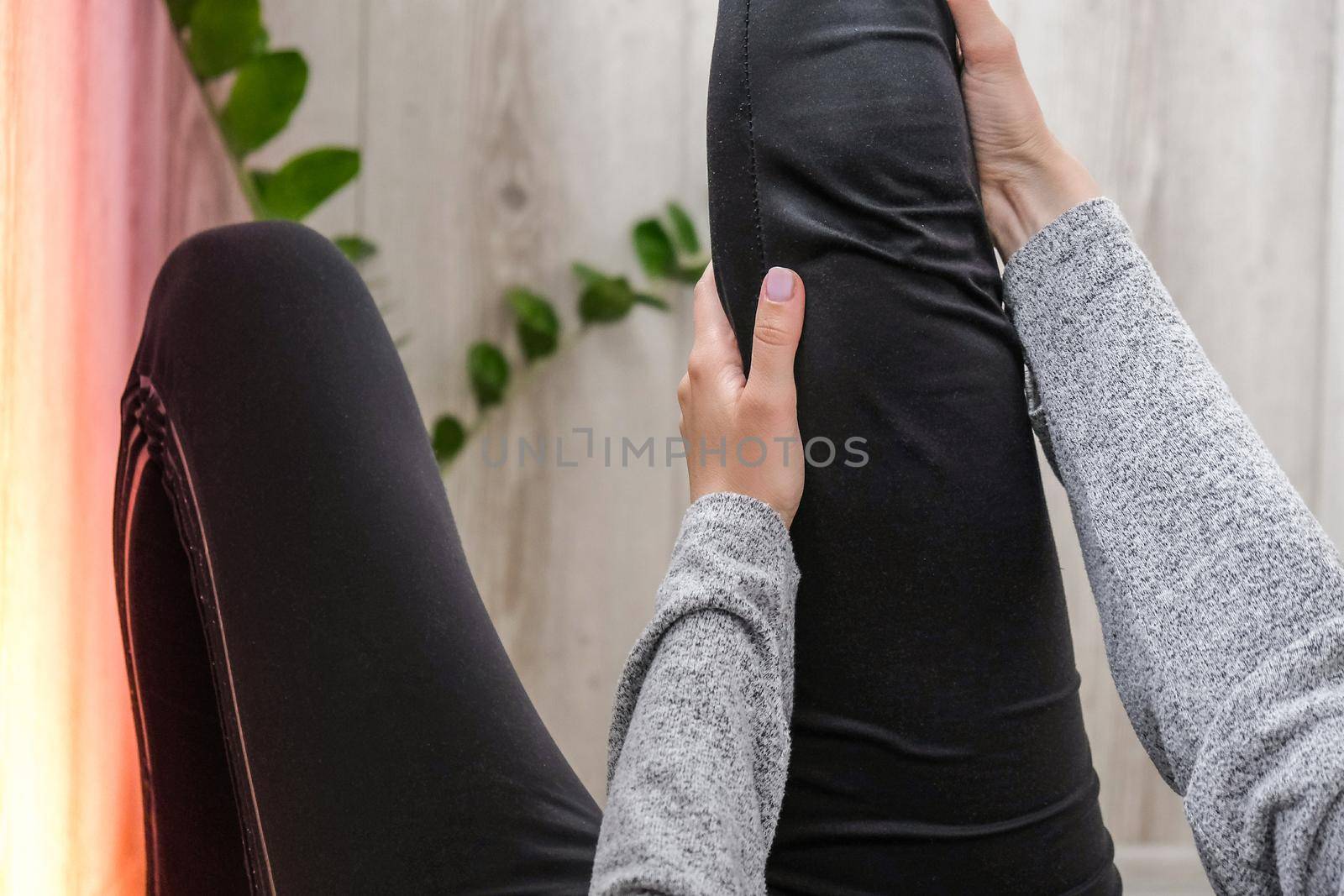 Young millennial blonde woman doing yoga exercise stretching fitness at balcony home. Mindfulness meditation. Relax breathe easy pose gym healthy lifestyle concept. Self-isolation is beneficial