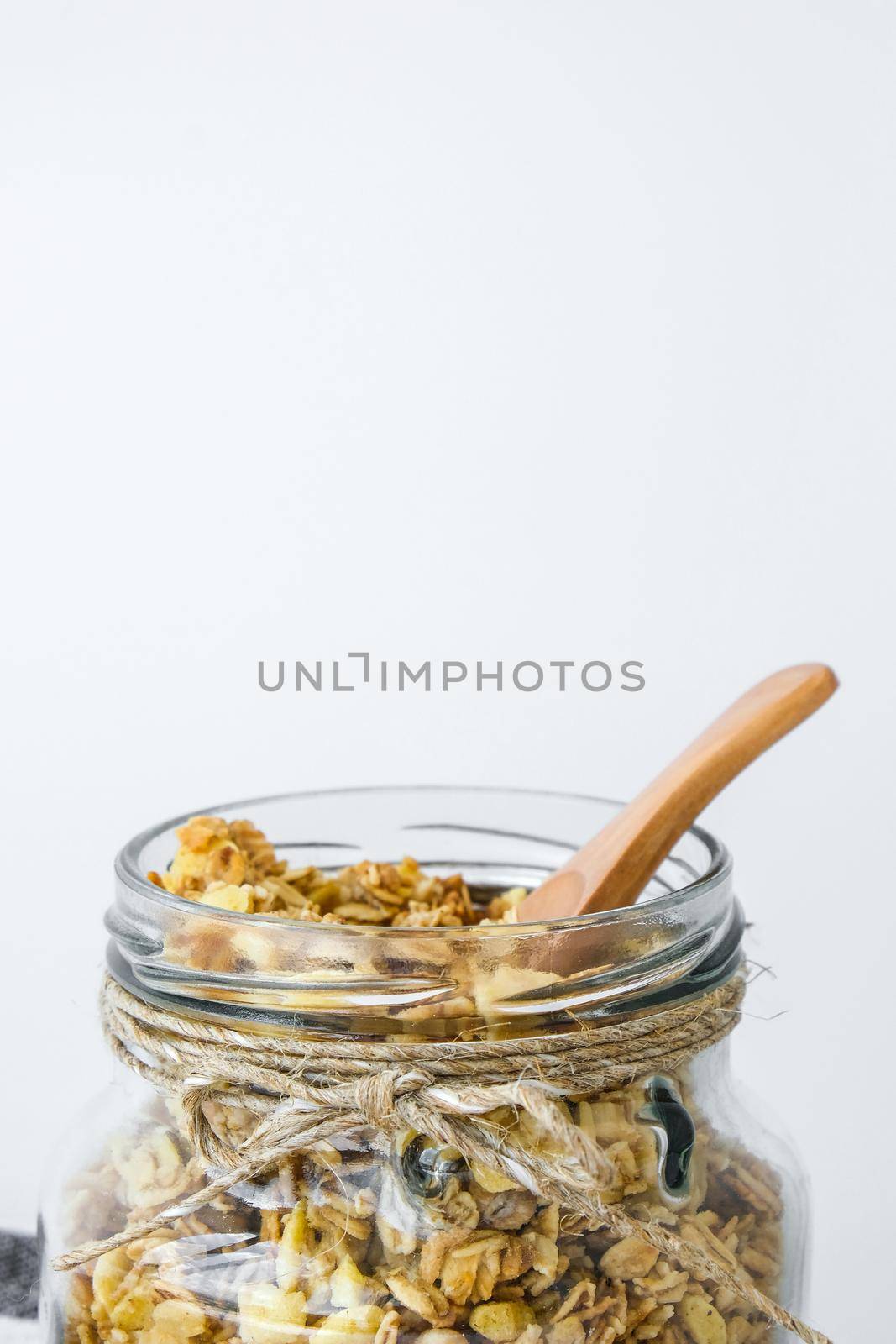 Healthy breakfast. Oatmeal Granola with greek yogurt and nuts banana muesli in jars on light background. Vegan, vegetarian and weight loss diet concept. Detox menu. Healthy eating food