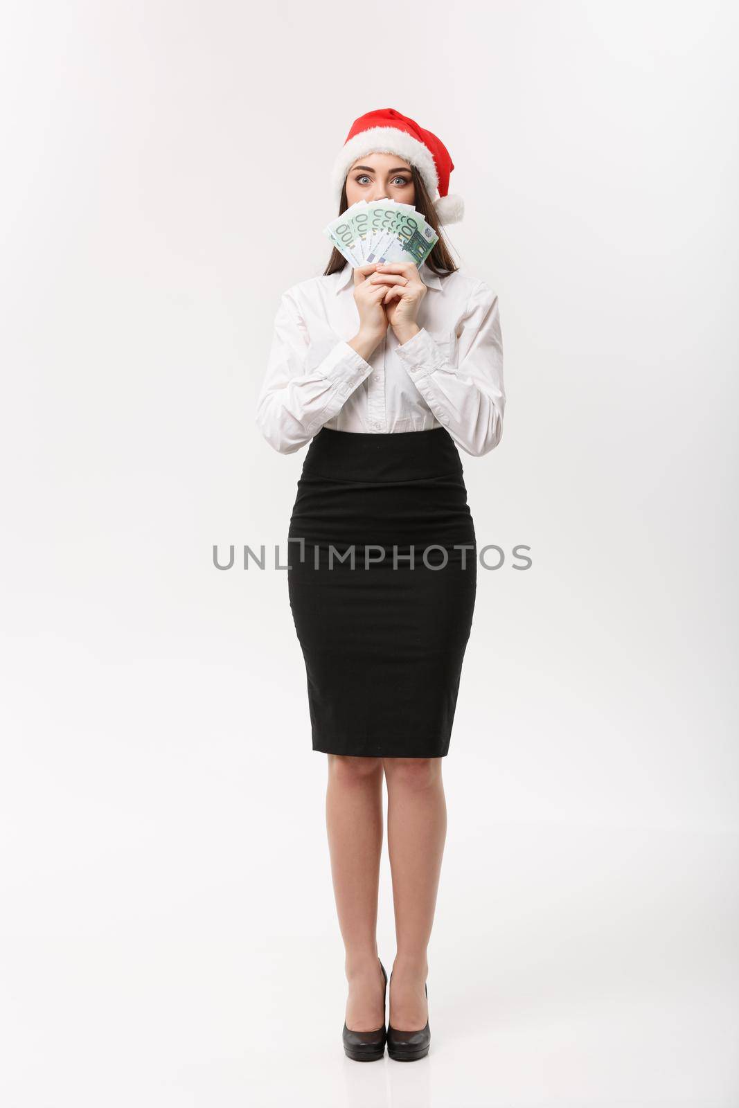 Christmas and finance concept - Young business woman showing money closing her face with surprise expression. by Benzoix