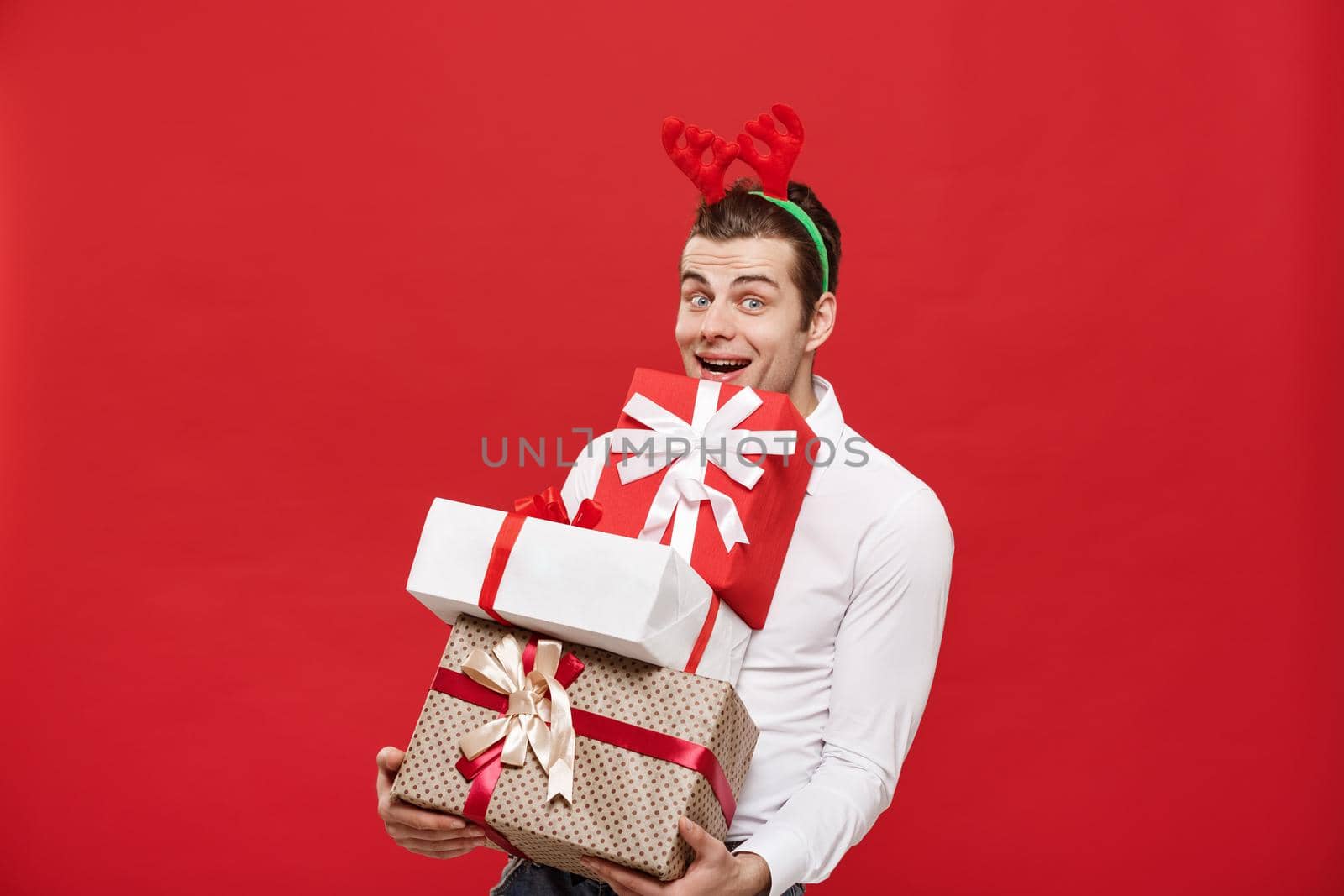 Christmas Concept - Handsome caucasian happy businessman holding a lot of gifts with wear santa hat posing on white isolated background.