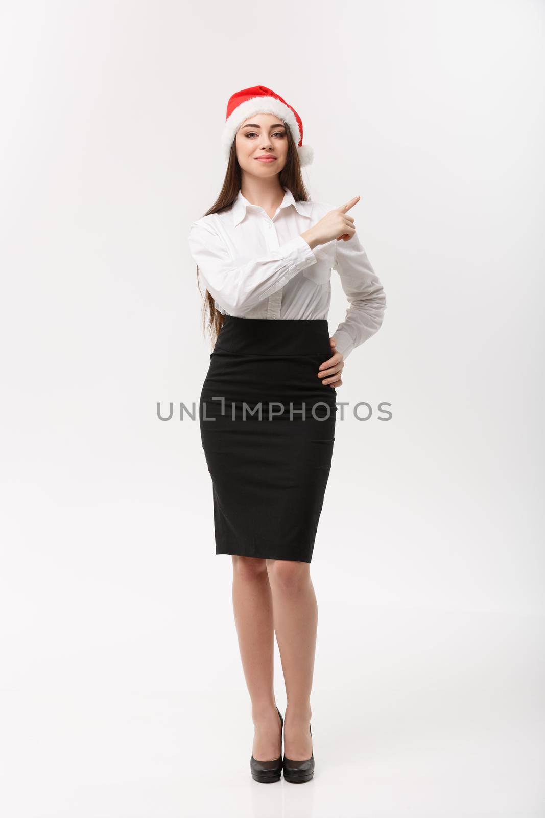 Business Concept - Modern caucasian business woman in the white studio background pointing finger onside presenting product. by Benzoix