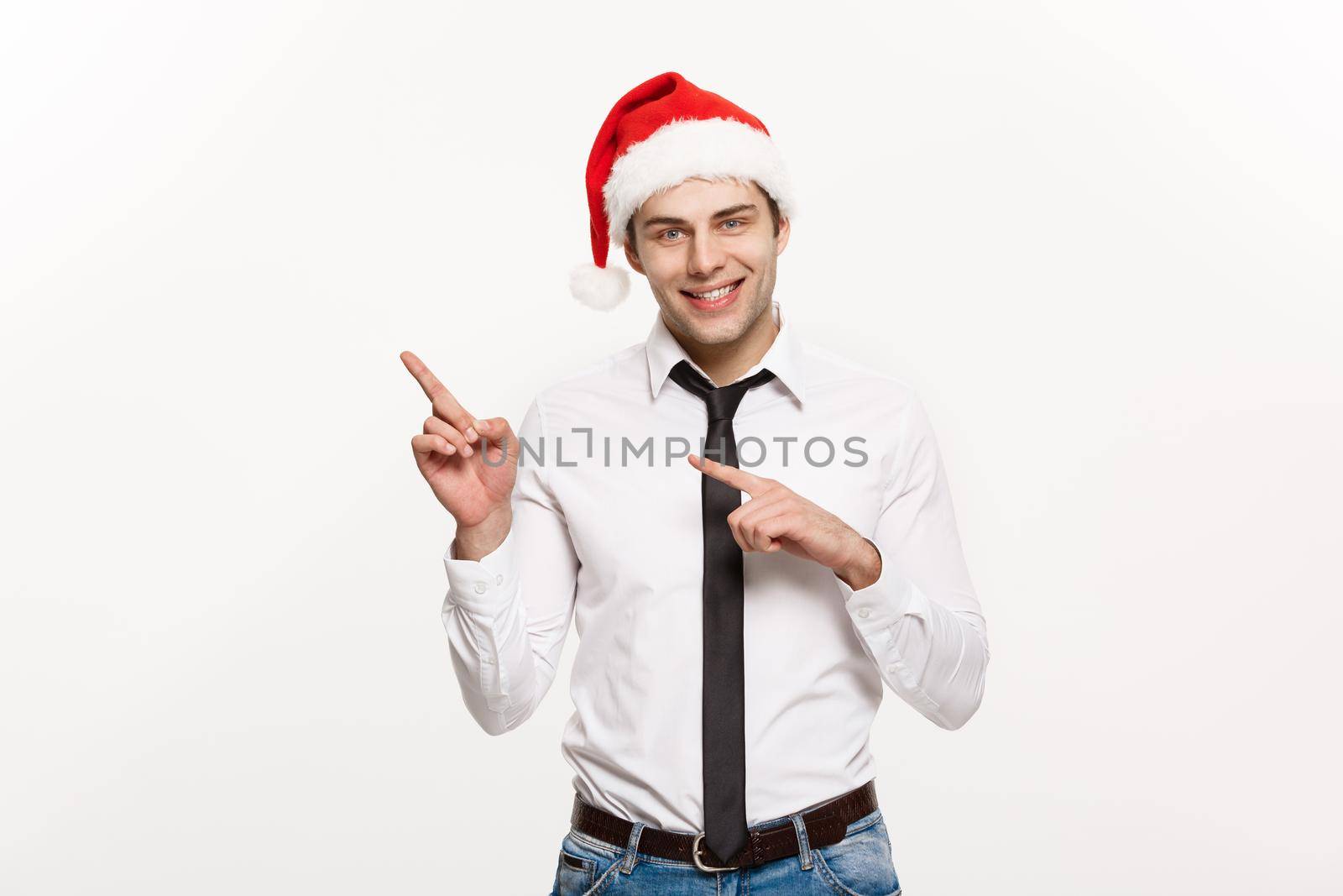 Christmas Concept - Handsome Business man wear santa hat pointing finger on side with white isolated background.