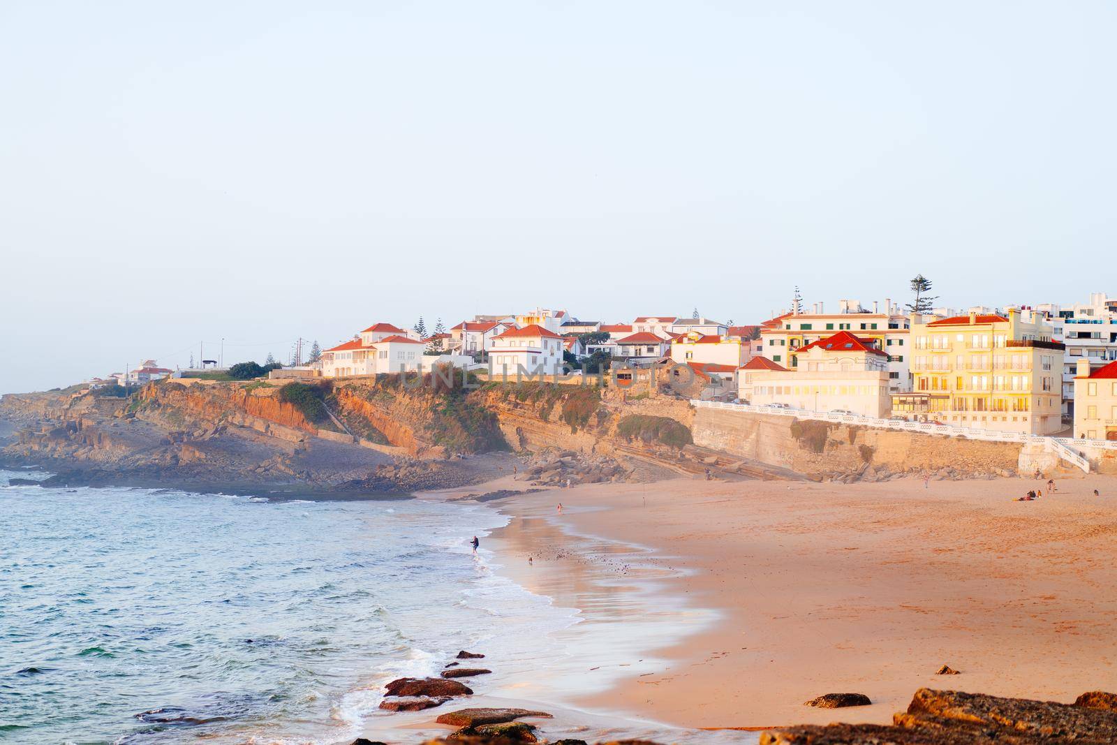 Praia das Macas Apple Beach in Colares, Portugal, on a stormy day before sunset Small city on ocean shore