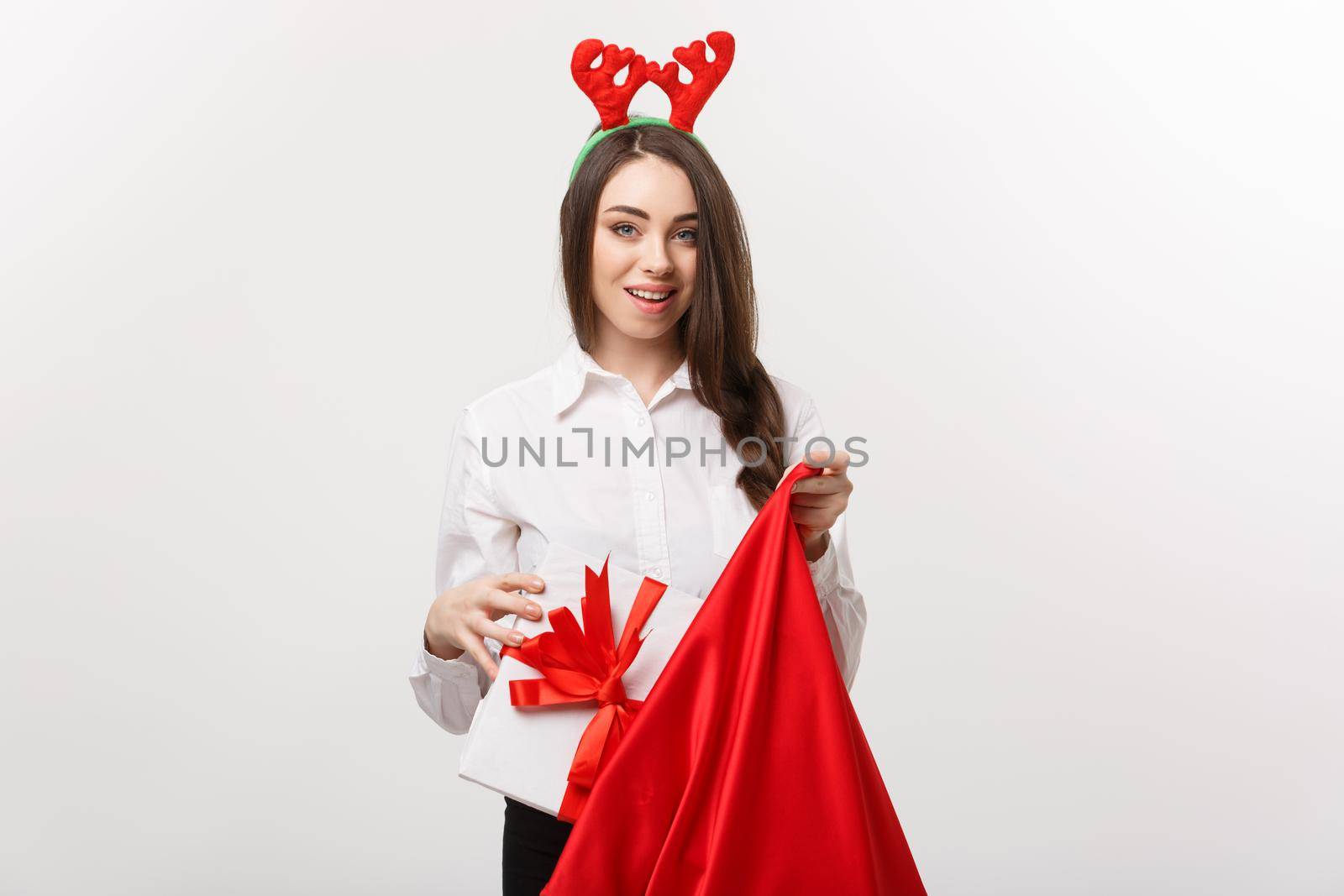 Christmas Concept - Young beautiful business woman happy with present in santa bag. by Benzoix