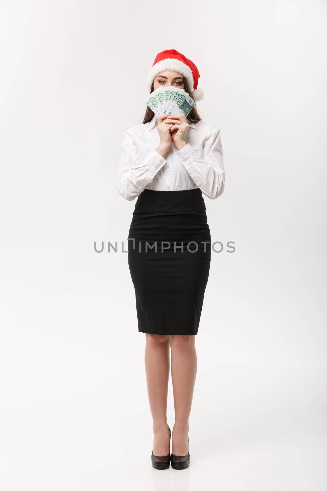 Christmas and finance concept - Young business woman showing money closing her face with surprise expression. by Benzoix