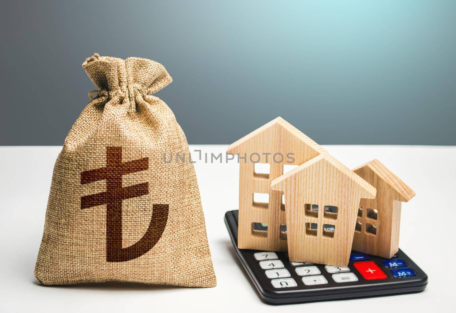 Houses on a calculator and turkish lira money bag. Buying and selling. Real estate valuation. Building maintenance. Mortgage loan. Utilities and services expenses. Taxes. Realty or rental business.