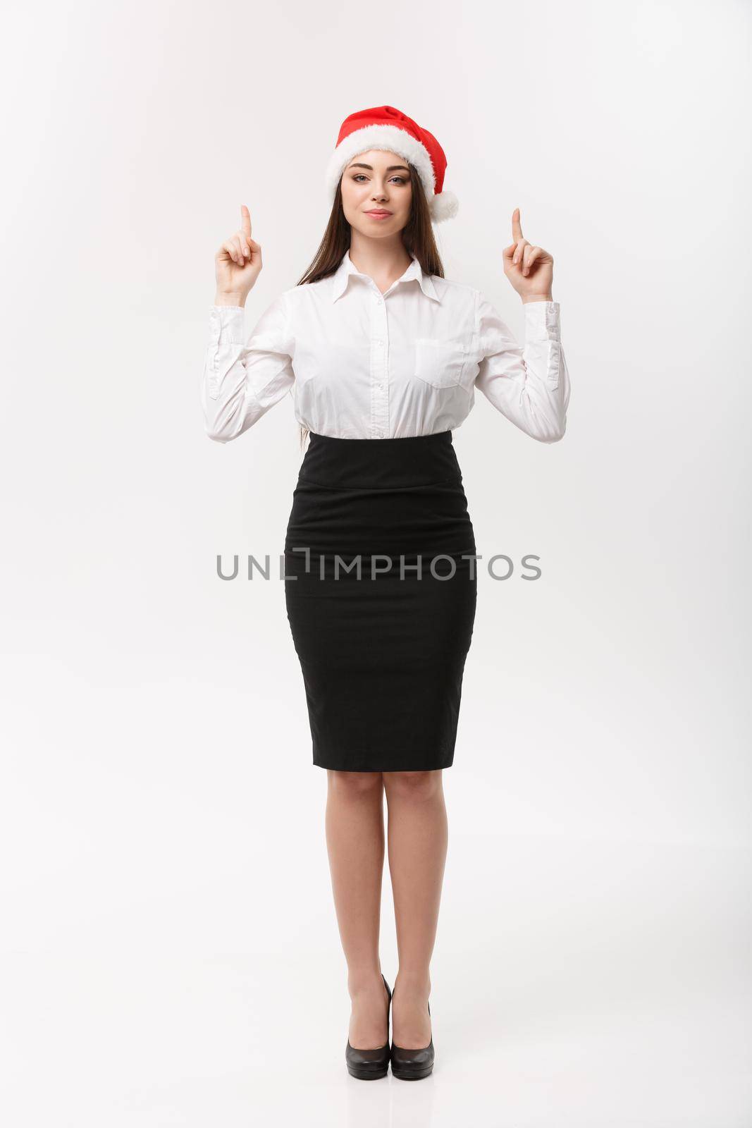 Business Concept - Modern caucasian business woman in the white studio background pointing finger upward presenting product. by Benzoix