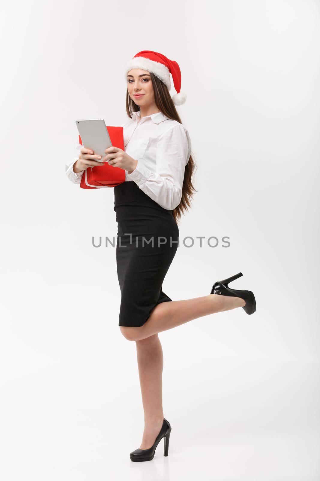 Business Concept - young business woman woking on digital tablet in Christmas day.