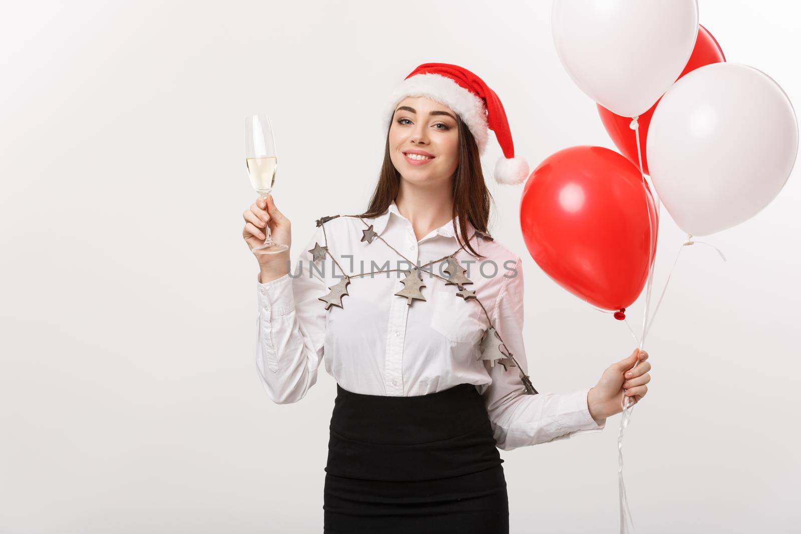 Christmas Celebration - Young beautiful business woman celebrating christmas with glass of champagne and balloon.