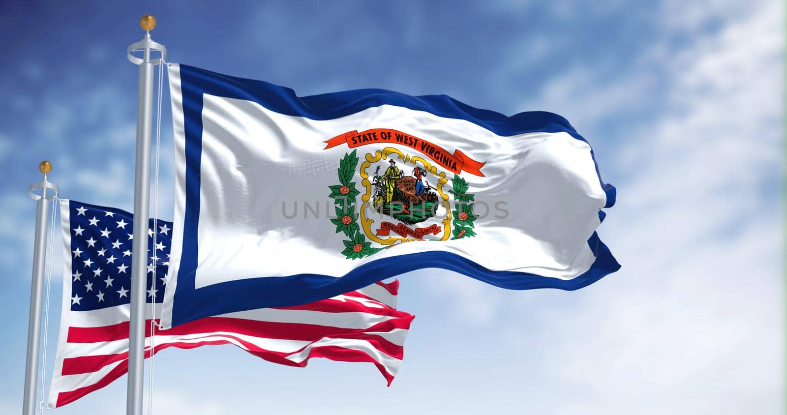 The West Virginia state flag waving along with the national flag of the United States of America. West Virginia is a state in the Southeastern region of the United States