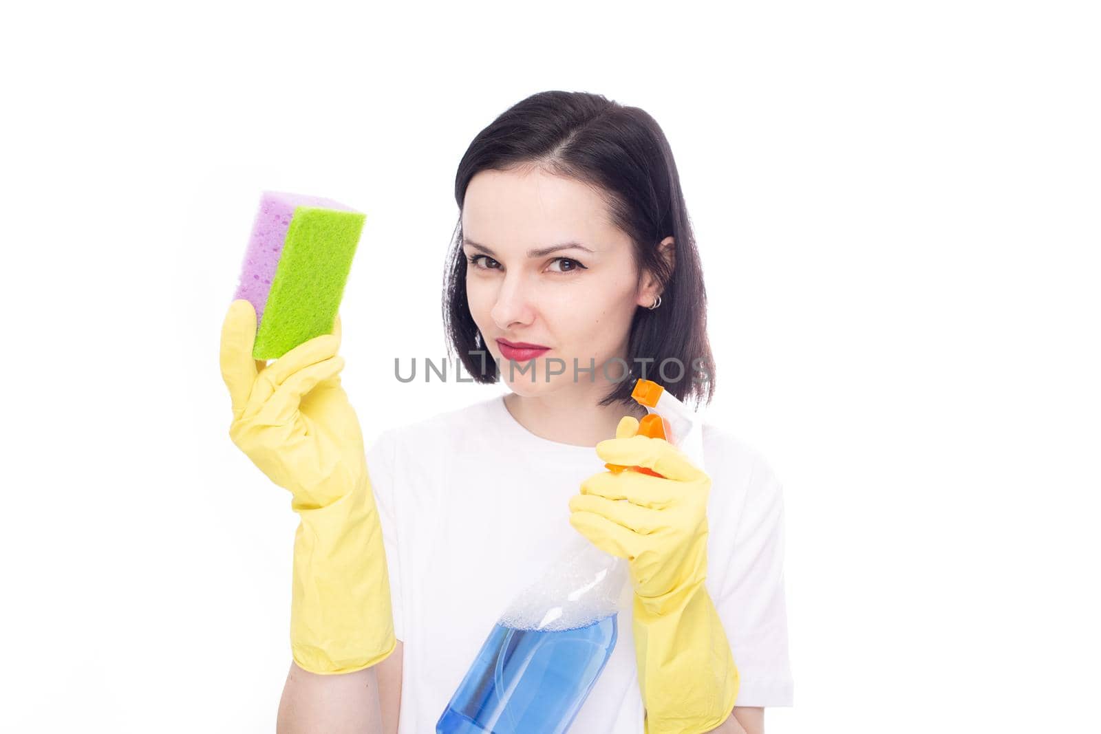 woman brunette cleaner in yellow gloves holding dishwashing sponge and window cleaner, white studio background. High quality photo