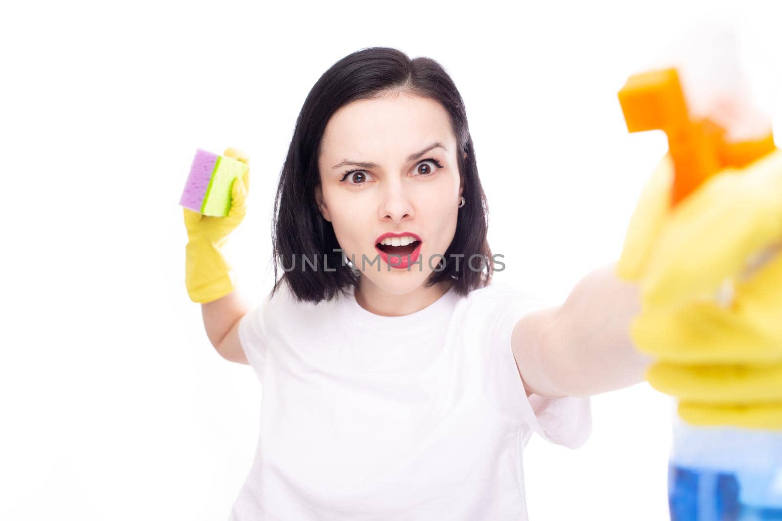 female cleaning lady, dressed in yellow gloves, holds window cleaner and dishwashing sponge in her hand, white studio background. High quality photo