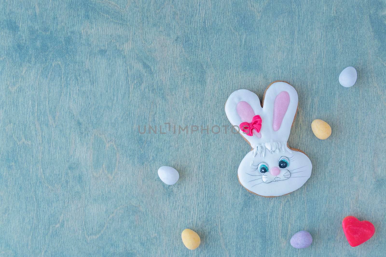 Easter bunny with chocolate eggs on a wooden green background with space for text. copy space, by Leoschka