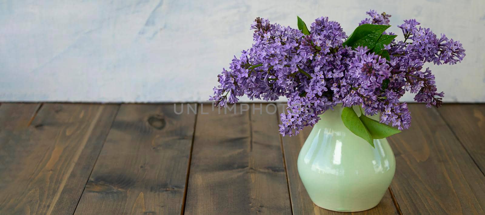 banner with Lilac flowers of very peri color in vase on wooden table. the concept of summer, spring, nature bloom. by Leoschka