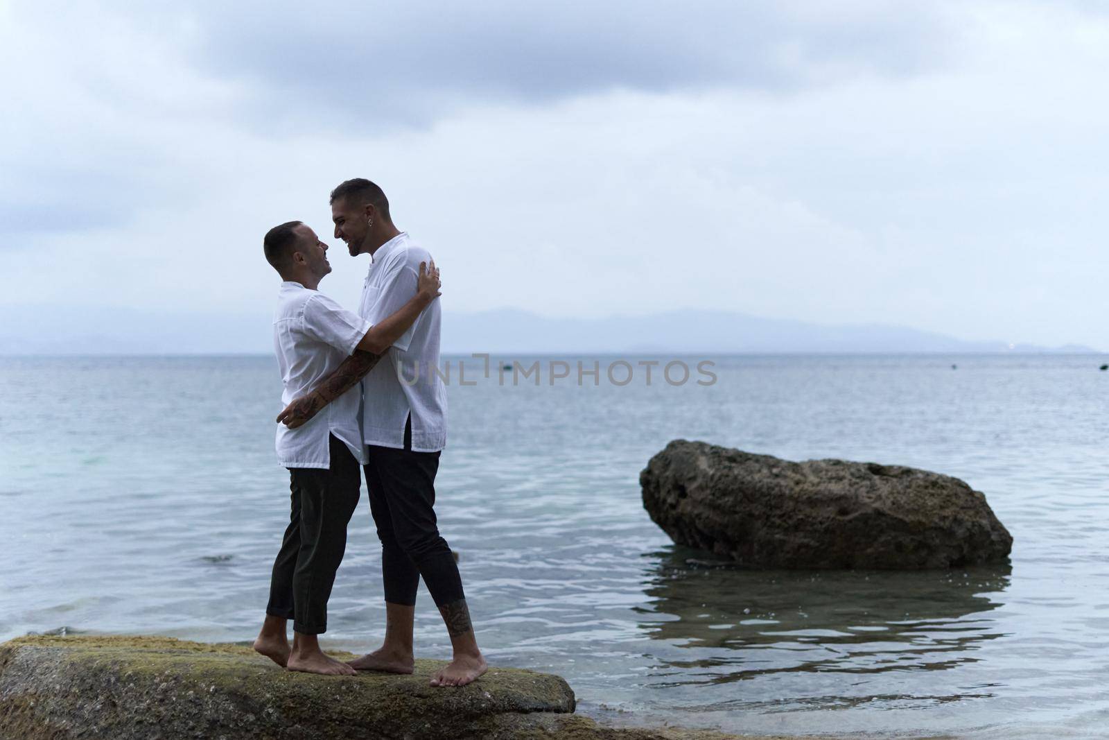 Gay couple about to kiss next to the ocean by WesternExoticStockers