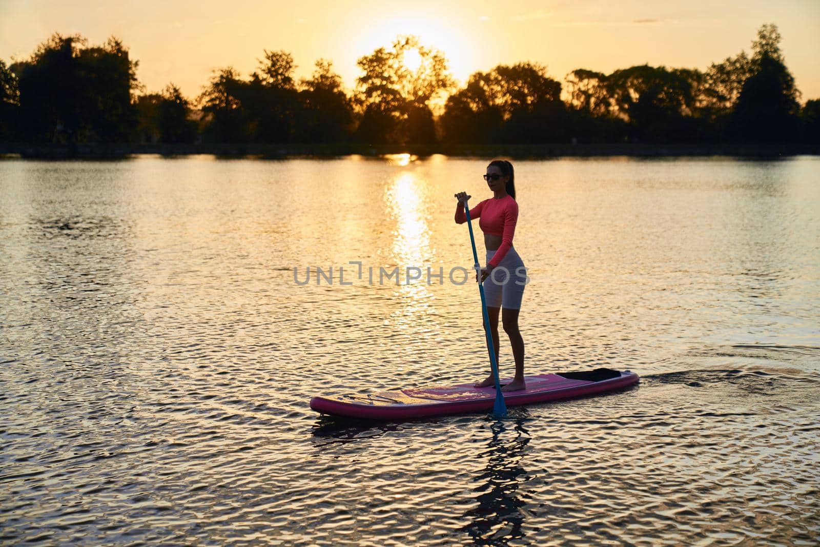 Woman spending evening time for practising in sup boarding by SerhiiBobyk