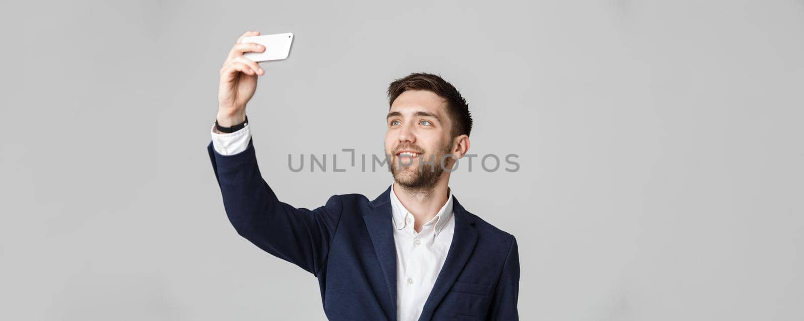 Business Concept - Handsome Business man take a selfie of himself with smartphone. White Background. by Benzoix