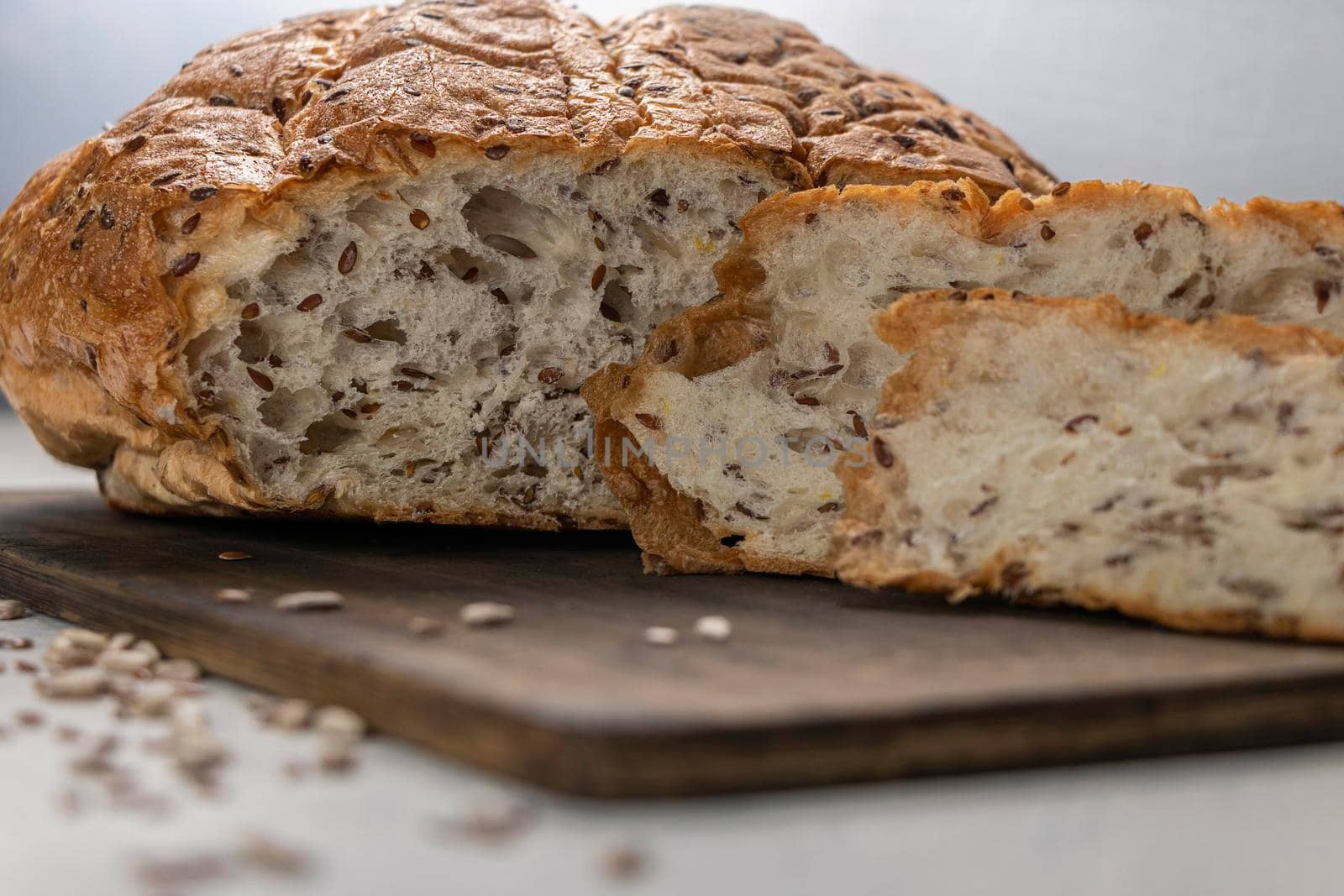 close-up of bread with seeds. sliced bread on a wooden board with flax seeds and sunflowers. soft focus