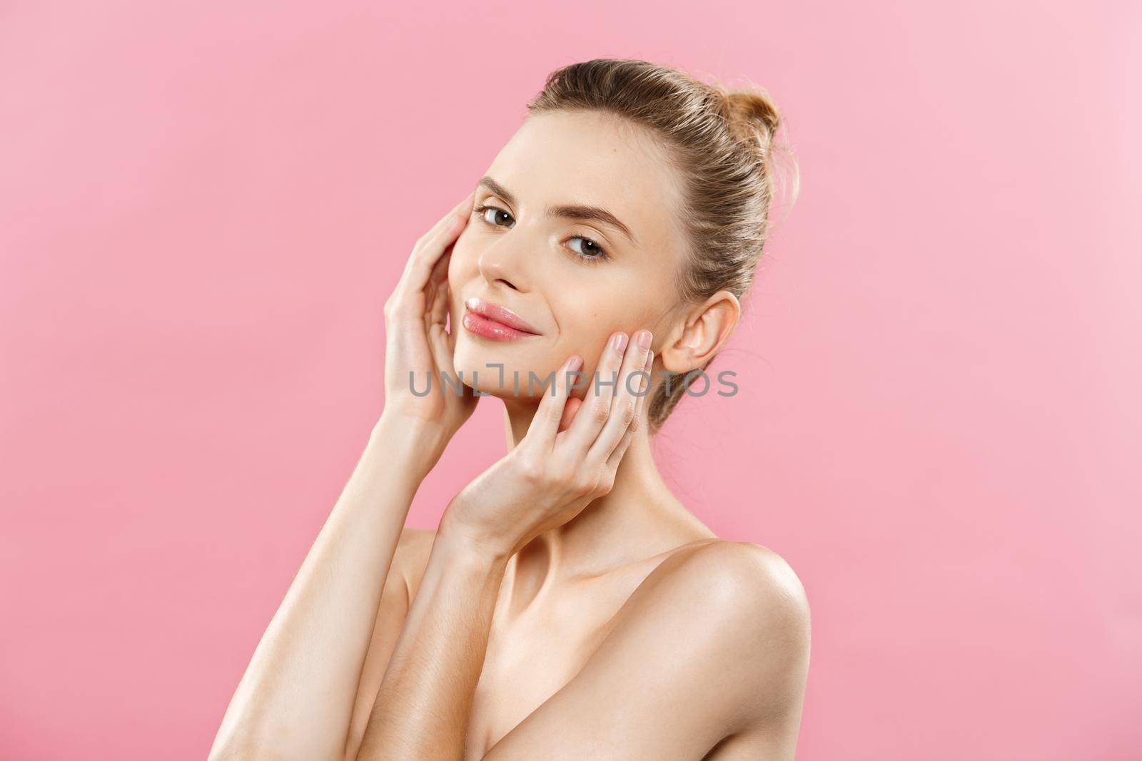 Beauty skin Concept - Beautiful Young Caucasian Woman with Clean Fresh Skin look away with pink studio background. Girl beauty face care. Facial treatment. Cosmetology.