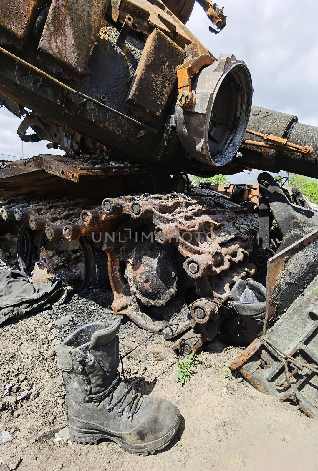 Kyiv region, Ukraine - May 15, 2022: War in Ukraine. Highway Kyiv - Zhytomyr. People take selfies against destroyed russian tank after russian atack in Febrary