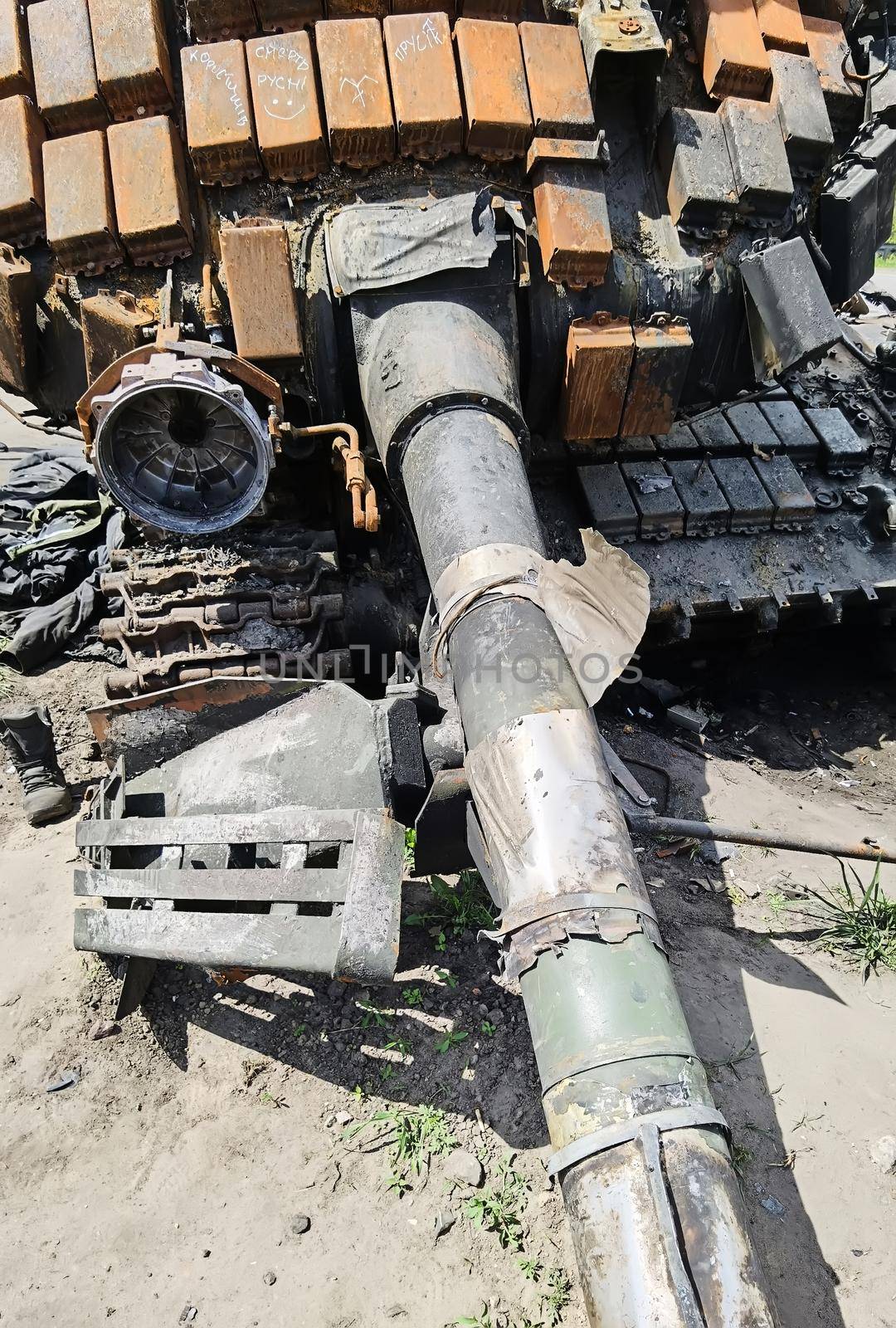 Kyiv region, Ukraine - May 15, 2022: War in Ukraine. Highway Kyiv - Zhytomyr. People take selfies against destroyed russian tank after russian atack in Febrary