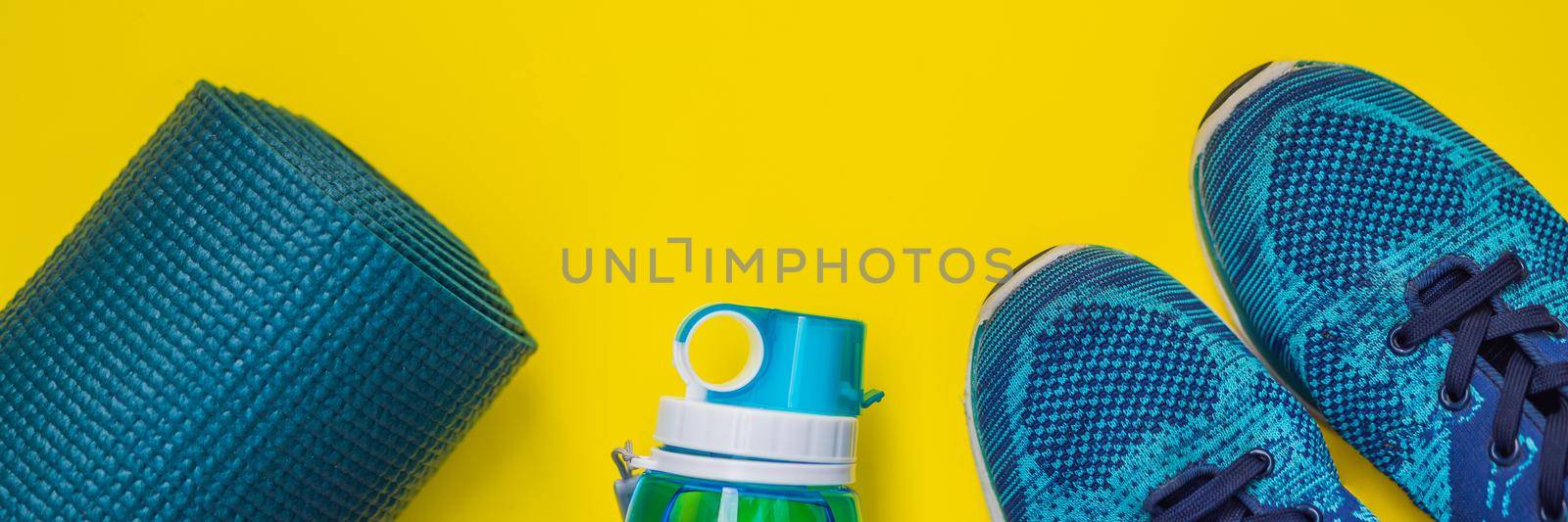 BANNER, LONG FORMAT Everything for sports turquoise, blue shades on a yellow background. Yoga mat, sport shoes sportswear and bottle of water. Concept healthy lifestyle, sport and diet. Sport equipment. Copy space by galitskaya