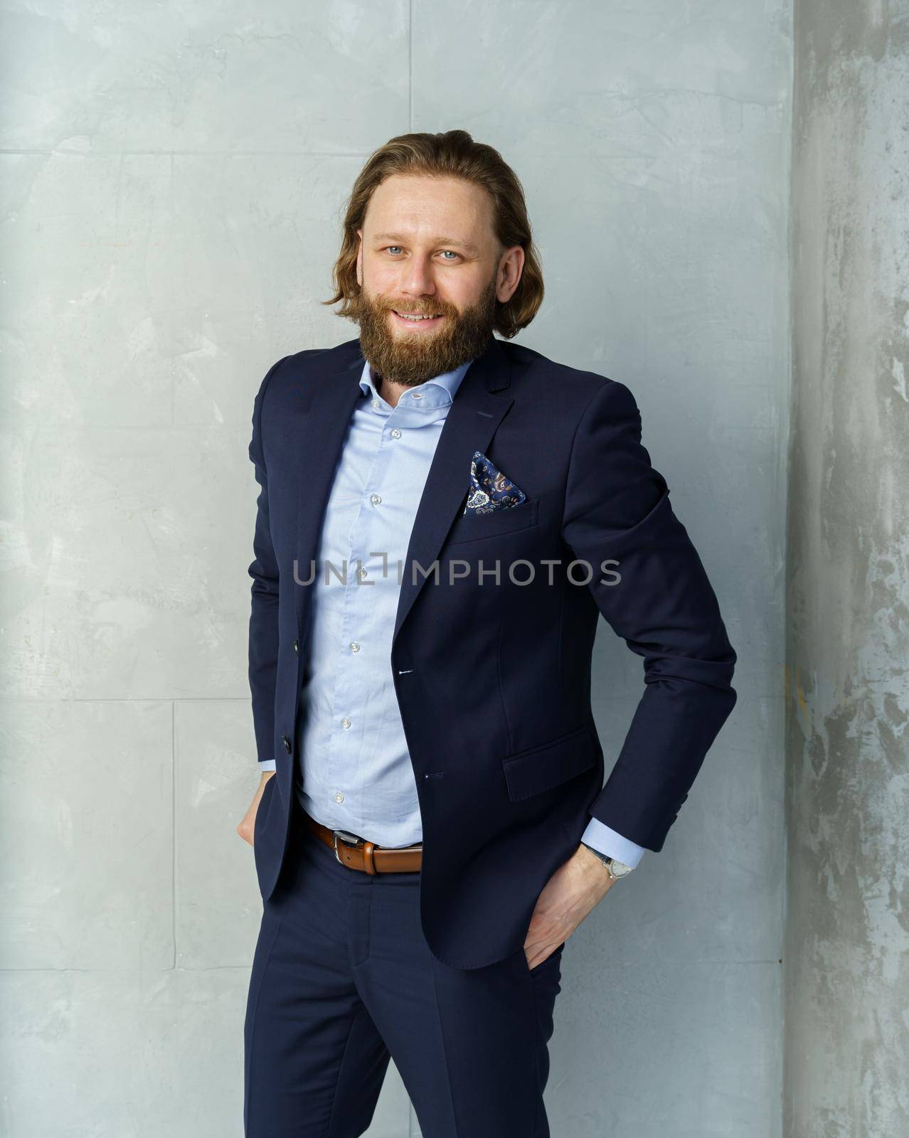 a handsome brutal bearded and long-haired man, a stylish businessman on a white background. High quality photo