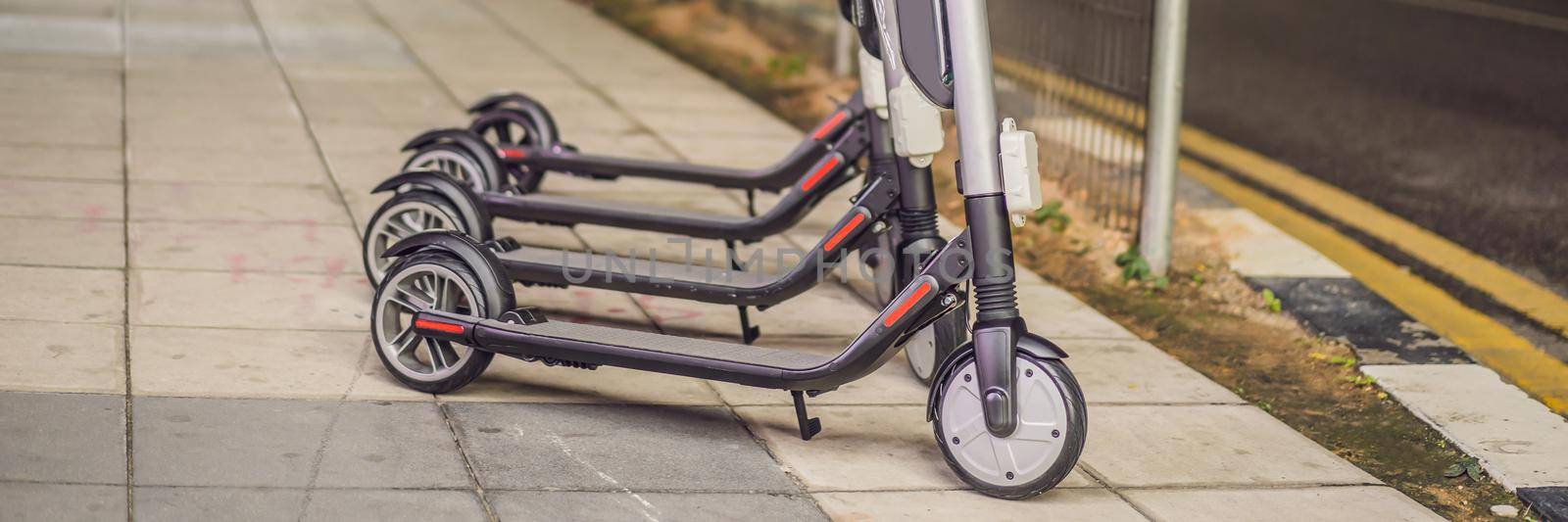 Electric scooters for rent. urban transport. Electric Ride Sharing Scooters Lined Up and Ready to Rent BANNER, LONG FORMAT by galitskaya