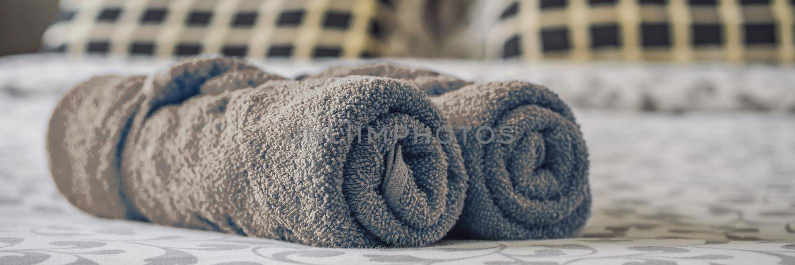 Freshly laundered fluffy towels on bed in hotel. BANNER, LONG FORMAT