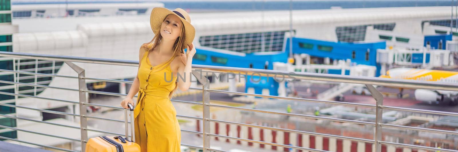 Start of her journey. Beautiful young woman ltraveler in a yellow dress and a yellow suitcase is waiting for her flight BANNER, LONG FORMAT by galitskaya