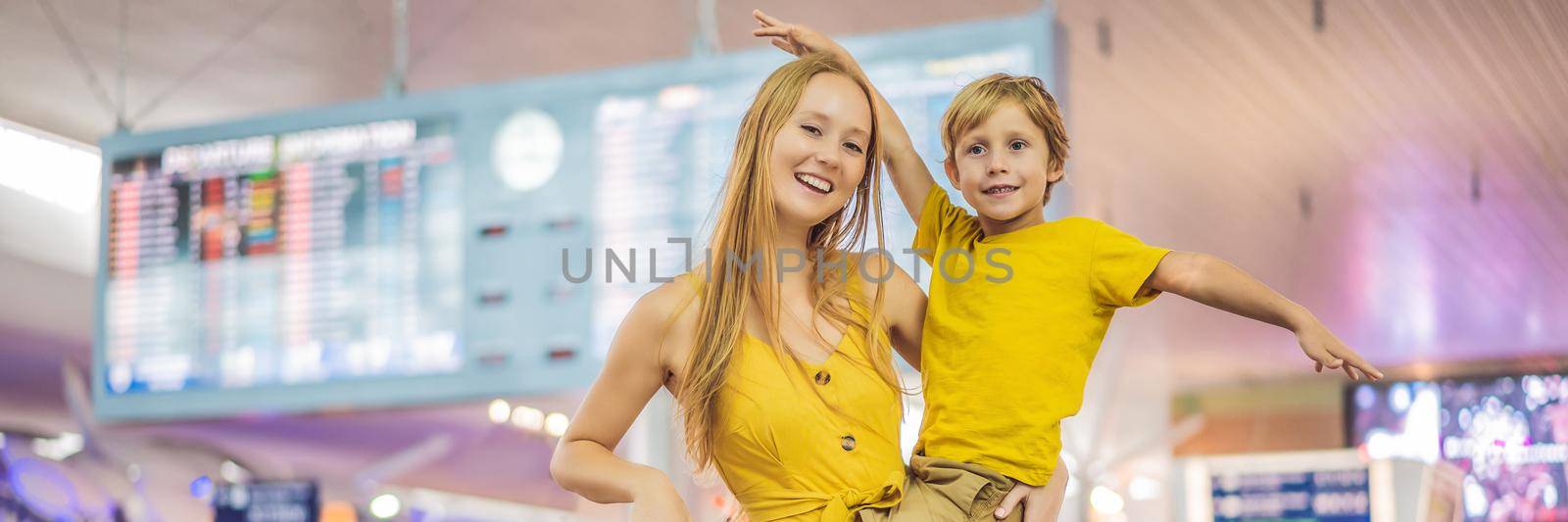 BANNER, LONG FORMAT Family at airport before flight. Mother and son waiting to board at departure gate of modern international terminal. Traveling and flying with children. Mom with kid boarding airplane. yellow family look by galitskaya