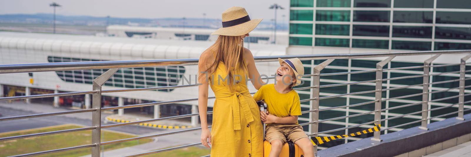 BANNER, LONG FORMAT Family at airport before flight. Mother and son waiting to board at departure gate of modern international terminal. Traveling and flying with children. Mom with kid boarding airplane. yellow family look by galitskaya