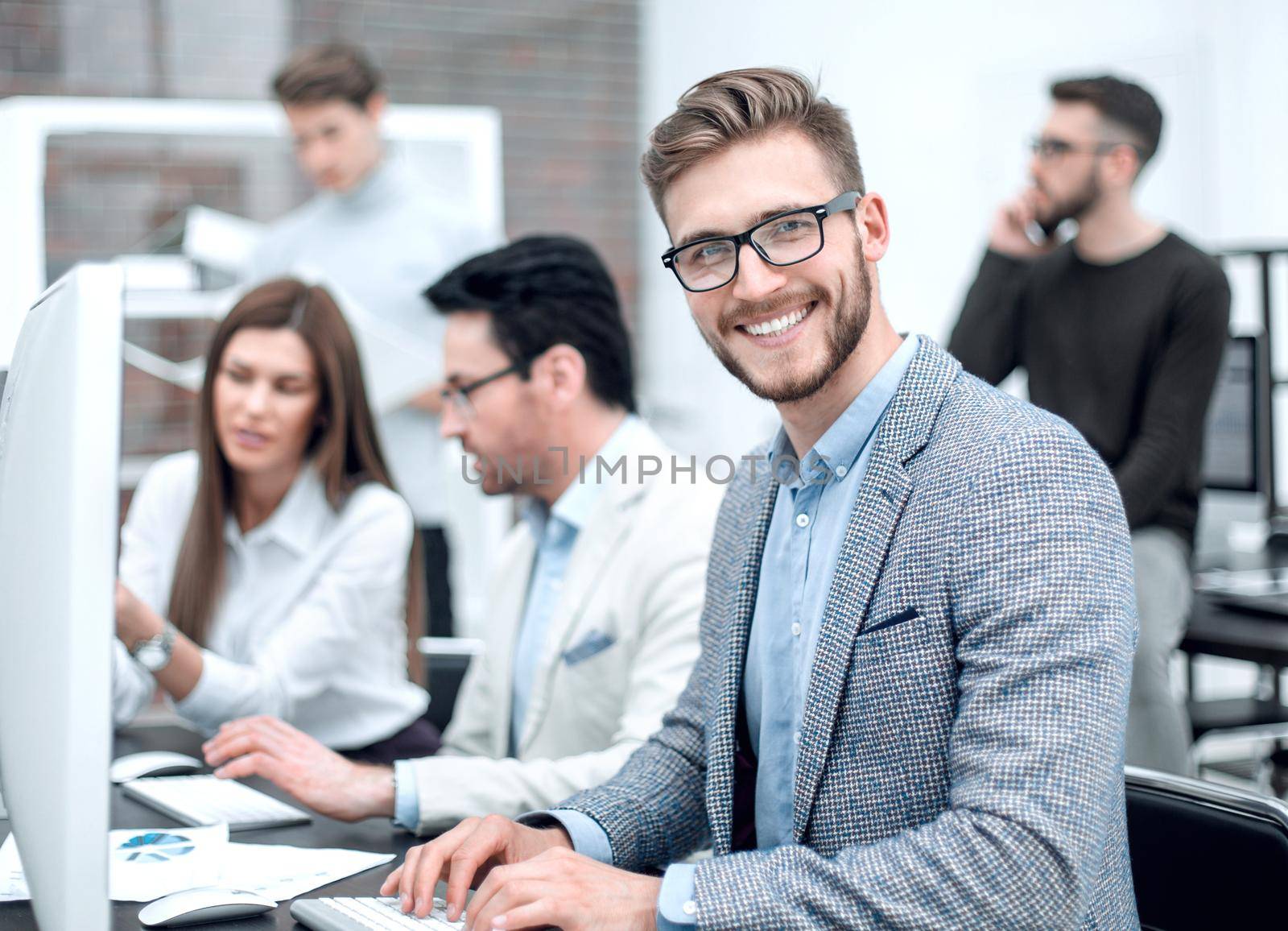 smiling businessman in the workplace .people and technology