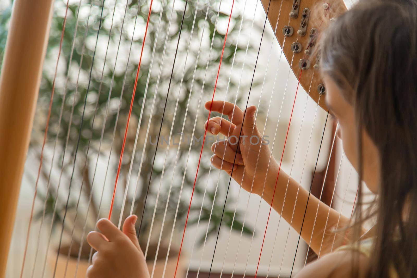 The child plays the harp. Selective focus. Kid.