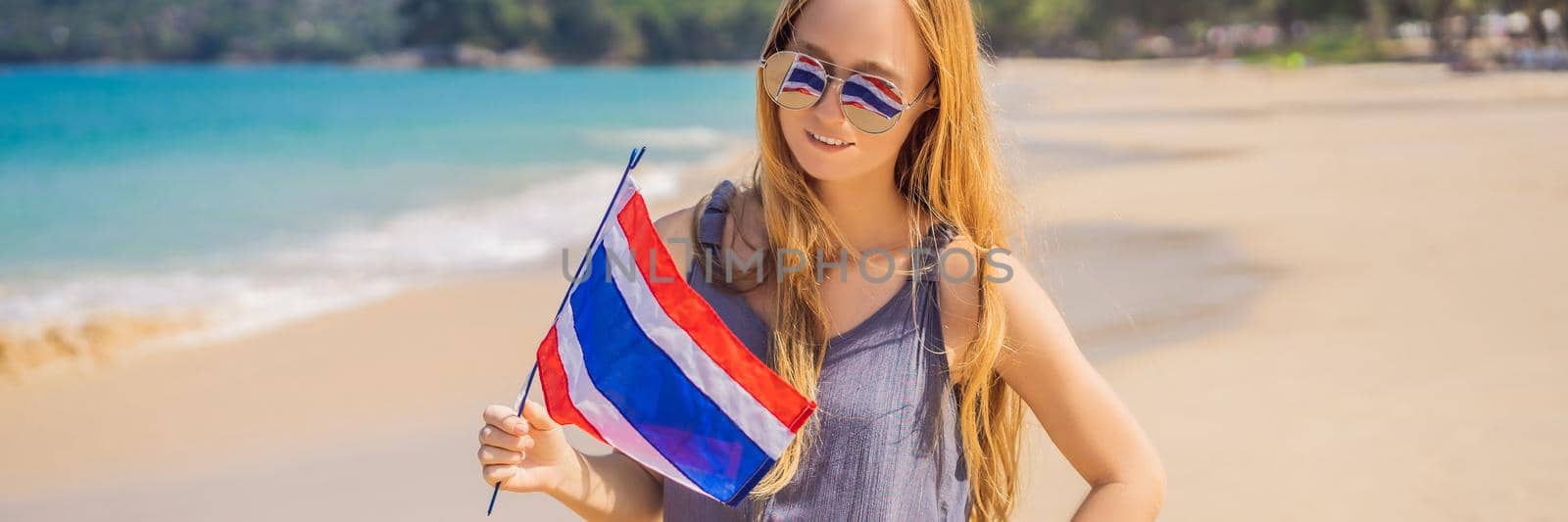 Happy woman having fun at the beach with Thailand flag. Beautiful girl enjoying travel to Asia. BANNER, LONG FORMAT