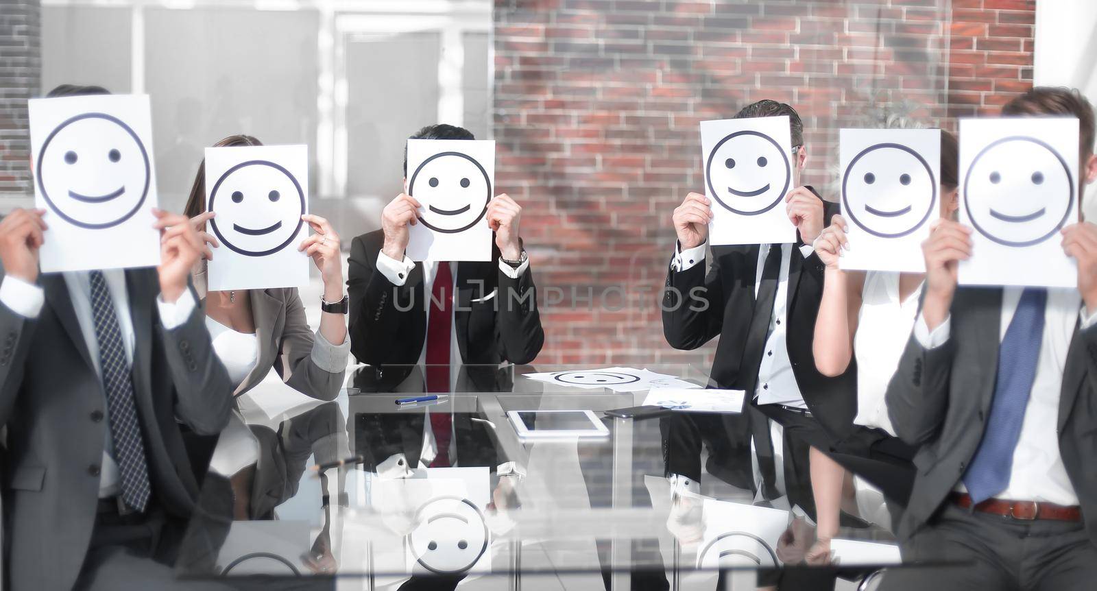 business team keeps smiley icons sitting at the Desk.business concept