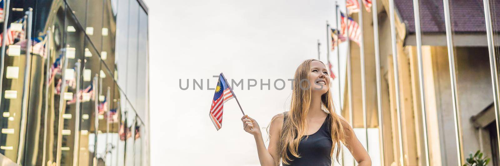 Young woman travels in Malaysia. Holds the Malaysian flag BANNER, LONG FORMAT by galitskaya