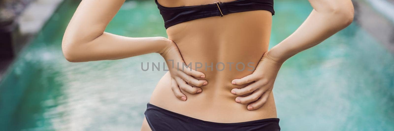 Women's back hurts against the backdrop of the pool. Pool helps with back pain. BANNER, LONG FORMAT