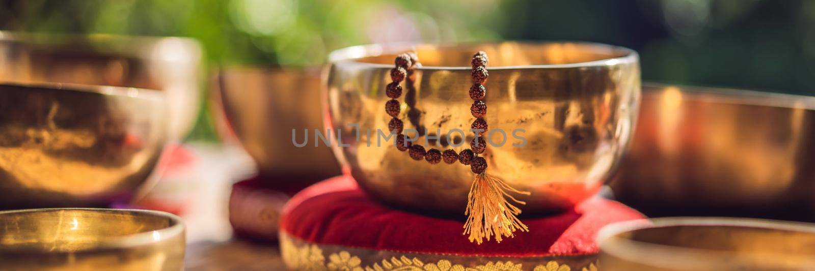 Tibetan singing bowls on a straw mat. BANNER, LONG FORMAT