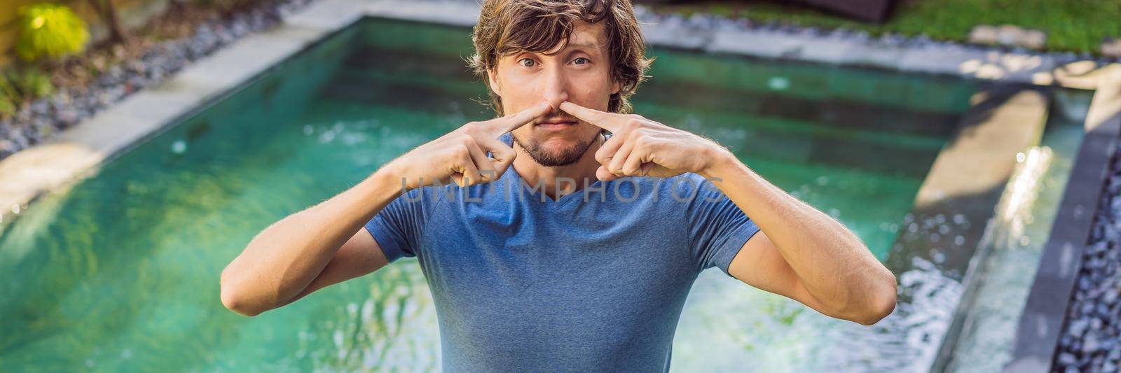 BANNER, LONG FORMAT Young man with disgust on his face pinches nose, something stinks, very bad smell in swimming pool because of pool chemicals. Negative emotion facial expression.