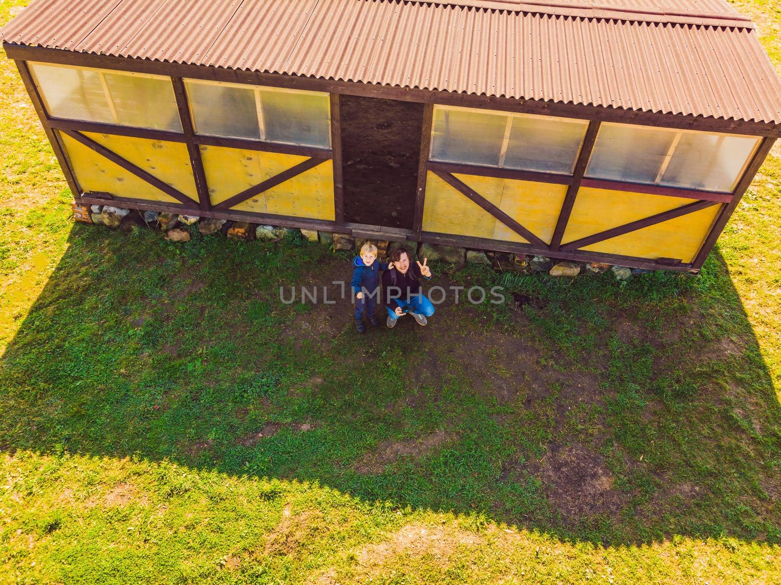 Father and son operating the drone by remote control. Young man with little boy flying drone, enjoying summer vacation by galitskaya