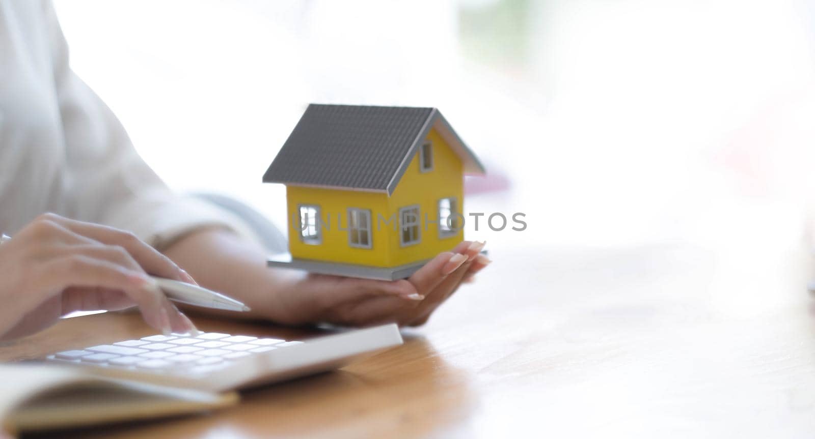 Selling a house with insurance, Salesperson or a home broker calculating the price to offer a special promotion and free insurance for customers who purchase a model home..