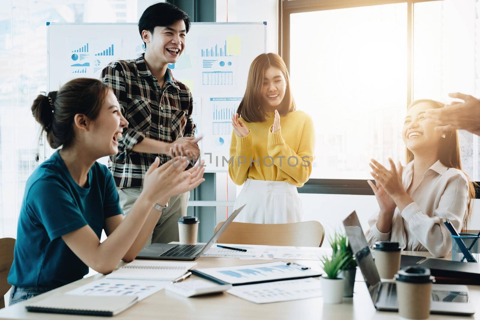 Group of young asian business people in smart casual wear working together in creative office using laptop. by nateemee