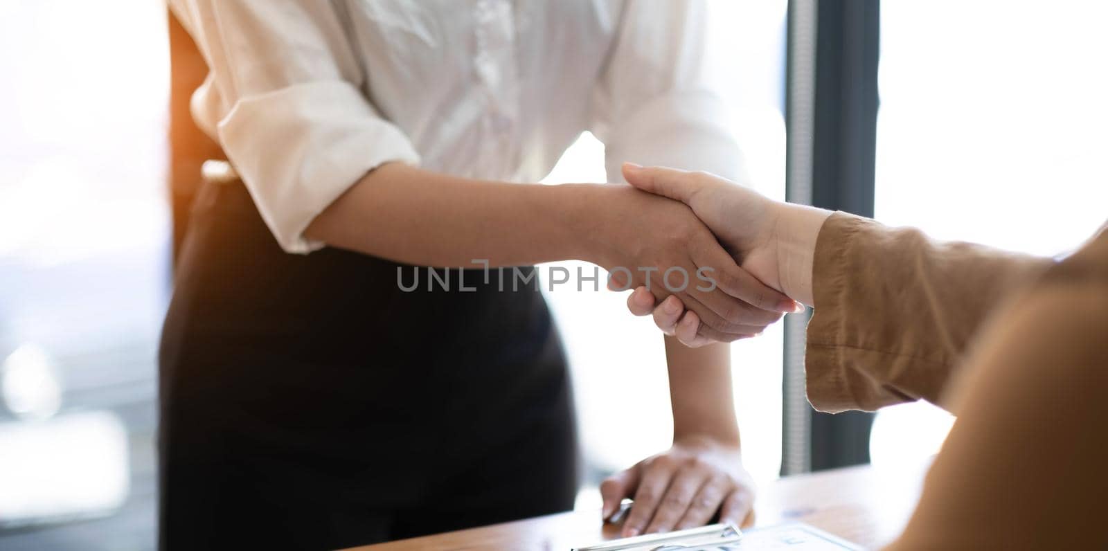 Real estate agents and customers shake hands to congratulate on signing a contract to buy a house with land and insurance, handshake and Good response concept..