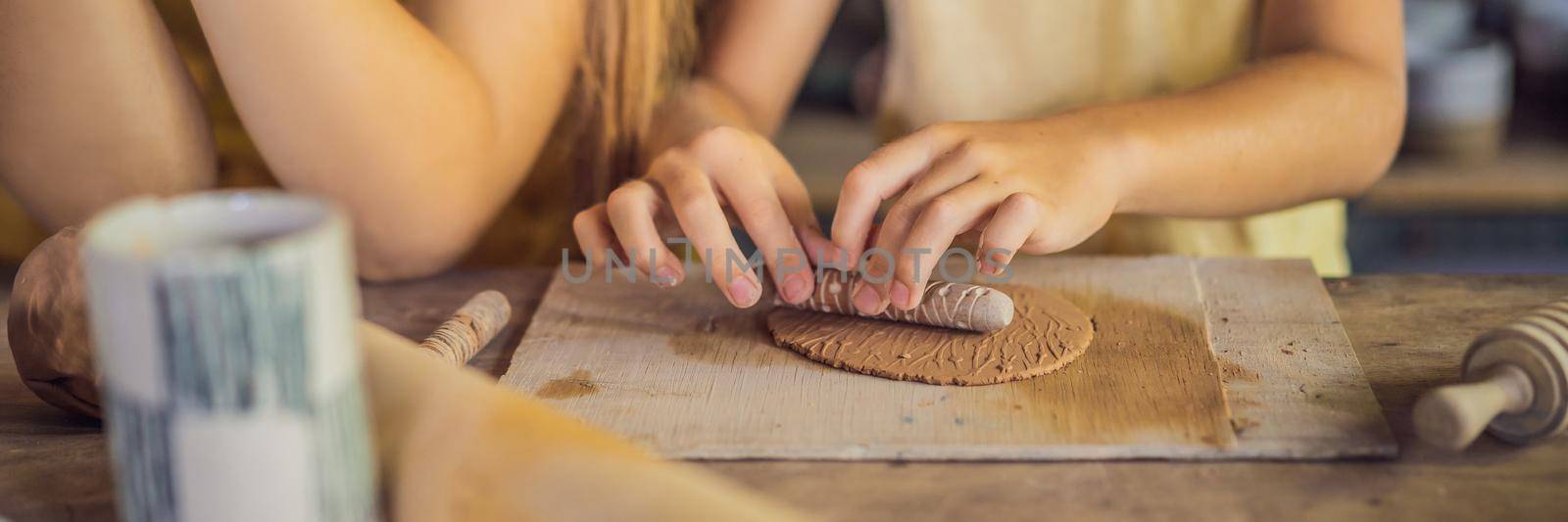 mother and son doing ceramic pot in pottery workshop. BANNER, LONG FORMAT