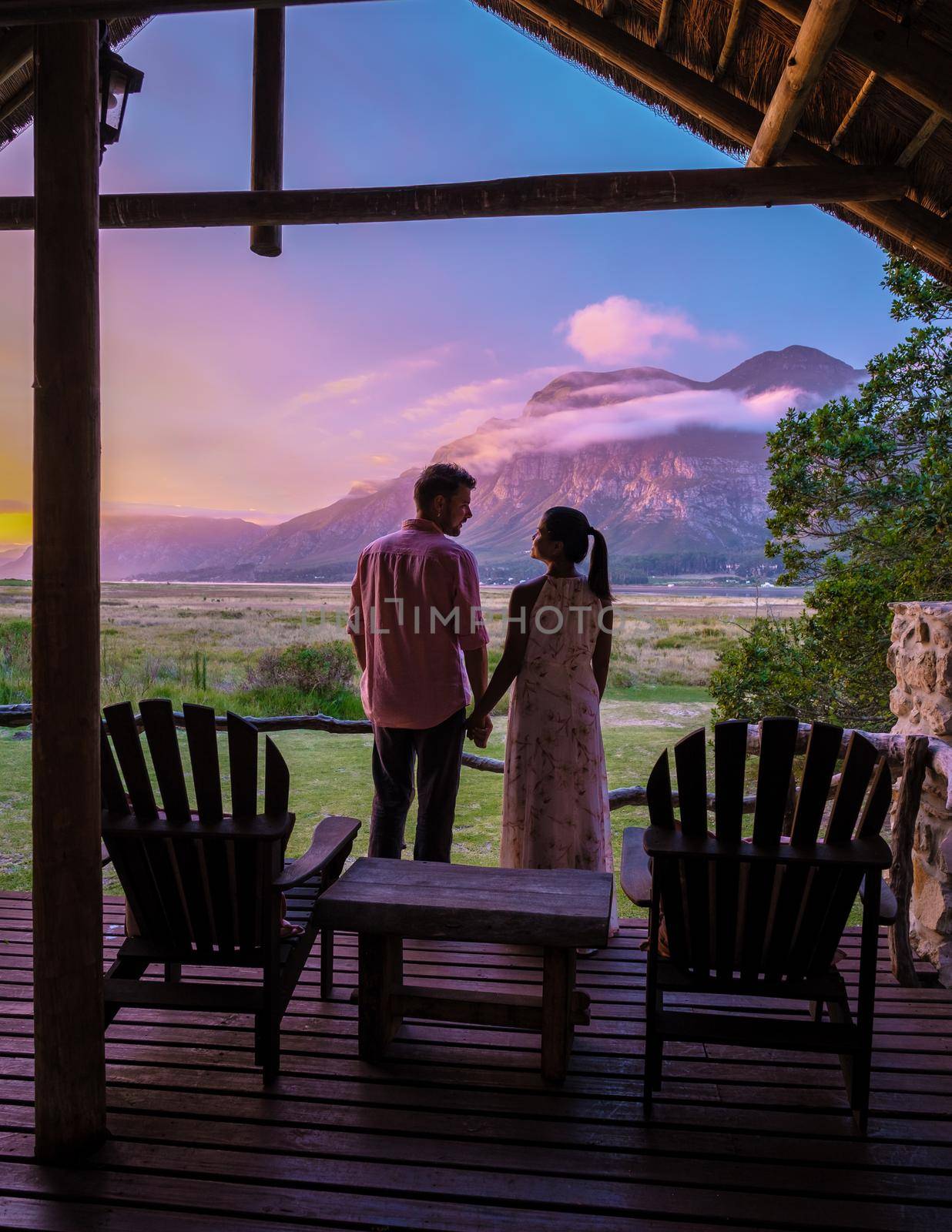 couple man and woman mid age in front of their lodge during vacation in South Africa, Mountains and grassland near Hermanus at the garden route Western Cape South Africa Whale coast by fokkebok