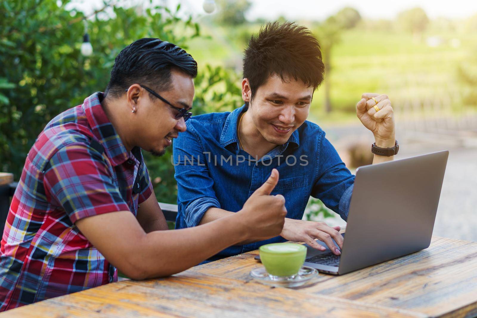 cheerful two man using and working on laptop computer by geargodz