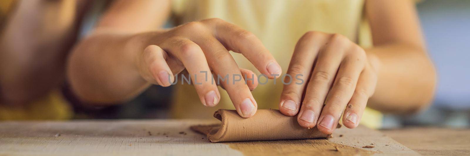 mother and son doing ceramic pot in pottery workshop BANNER, LONG FORMAT by galitskaya